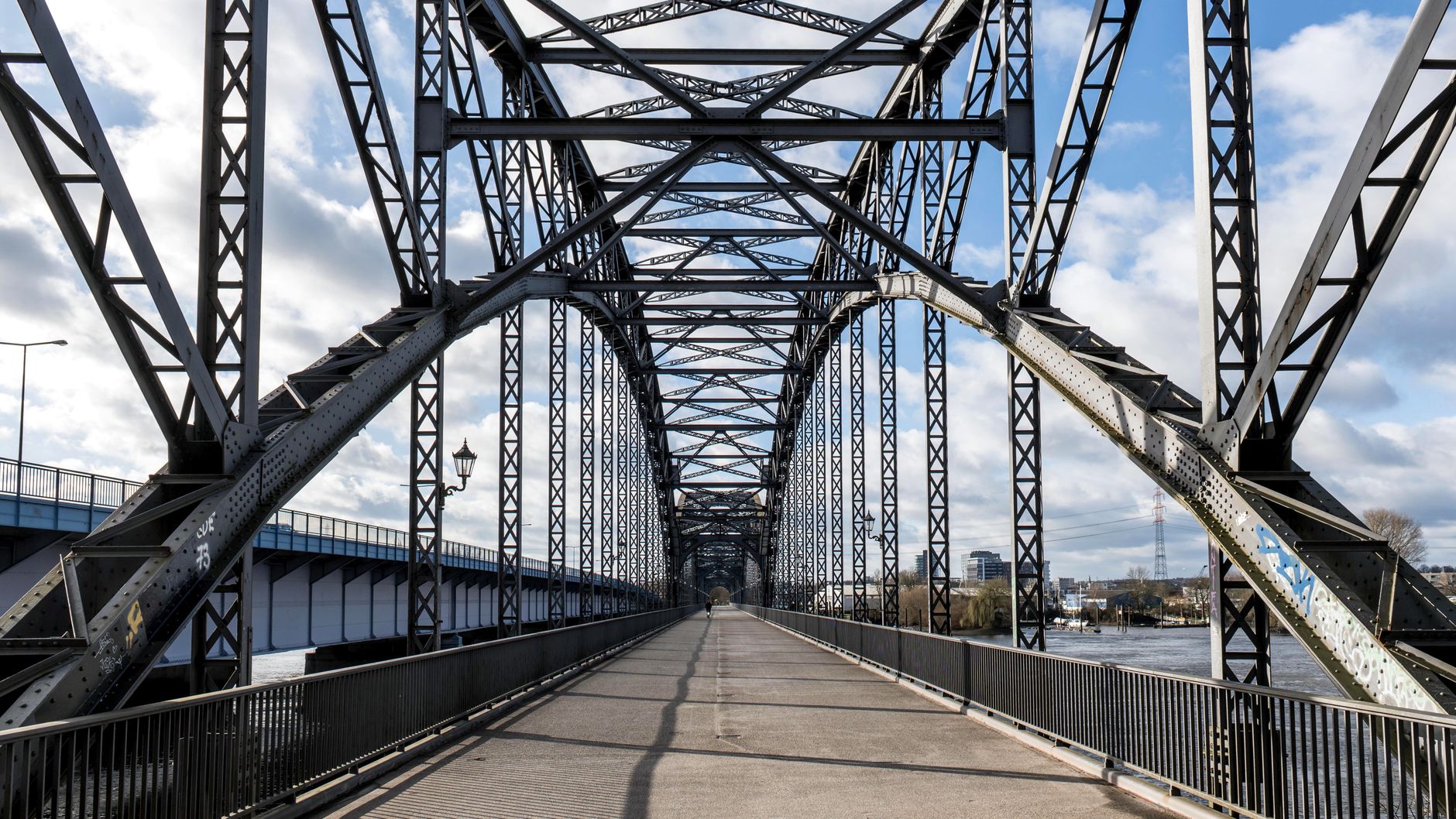 A striking steel arch bridge structure in Hamburg, Germany, under a bright sky.